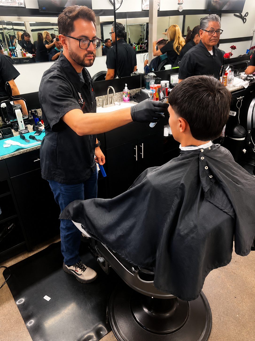 Barber giving a kid a fresh haircut at Super Barber Shop